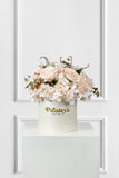 Floral arrangement in a white box with 'Paisley's Petals' branding on a white background