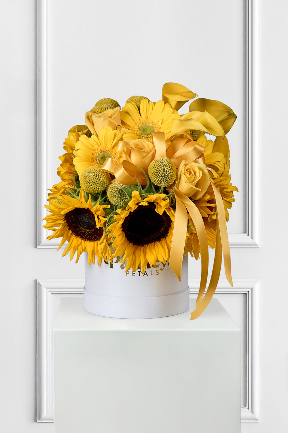Yellow flower arrangement with sunflowers in a white box on a white background