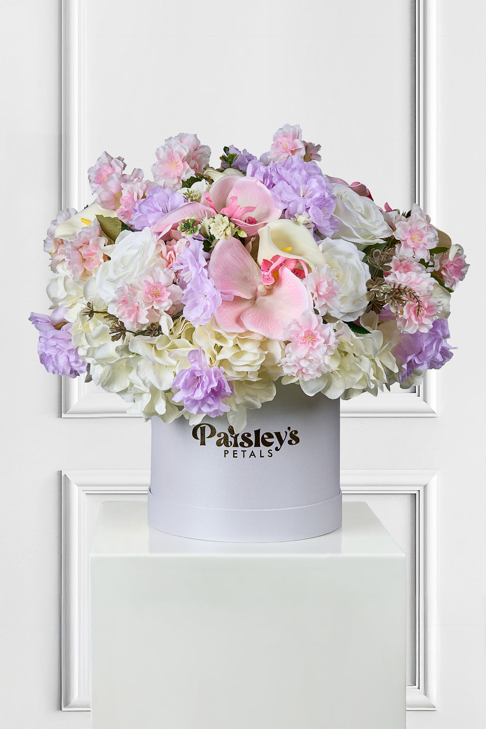Floral arrangement in a white box with 'Paisley's Petals' branding on a white background