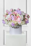 Floral arrangement in a white box with 'Paisley's Petals' branding on a white background
